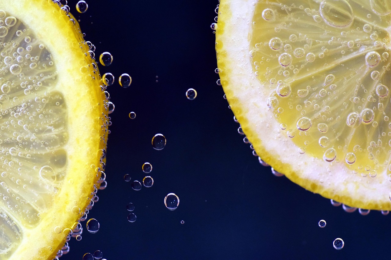 Lemon slices floating in a glass of lemonade with bubbles